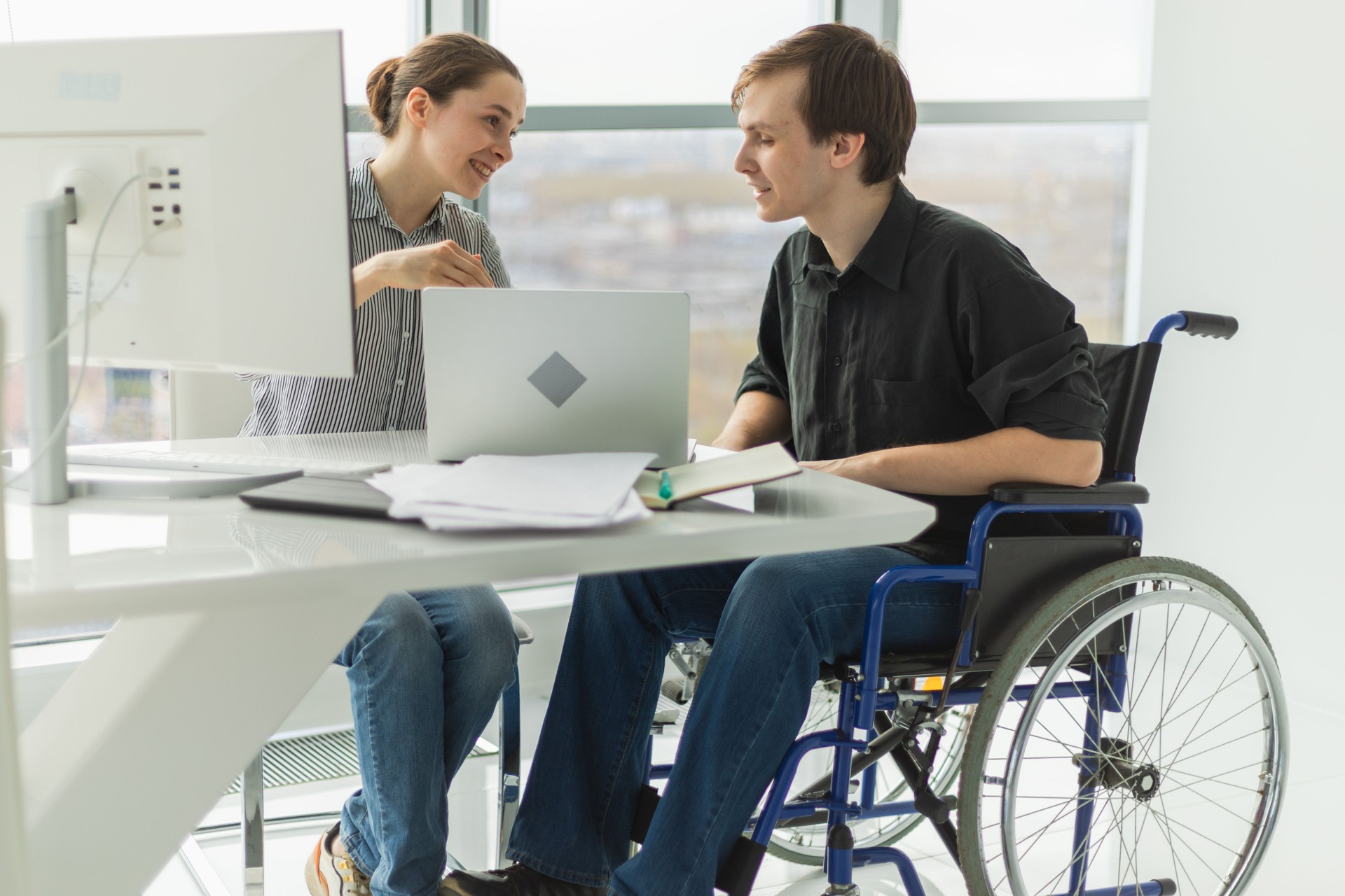 Colleagues business people woman man in chair for people with disability working on office. Startup business group team working together. Corporate professional team discussing project ideas.