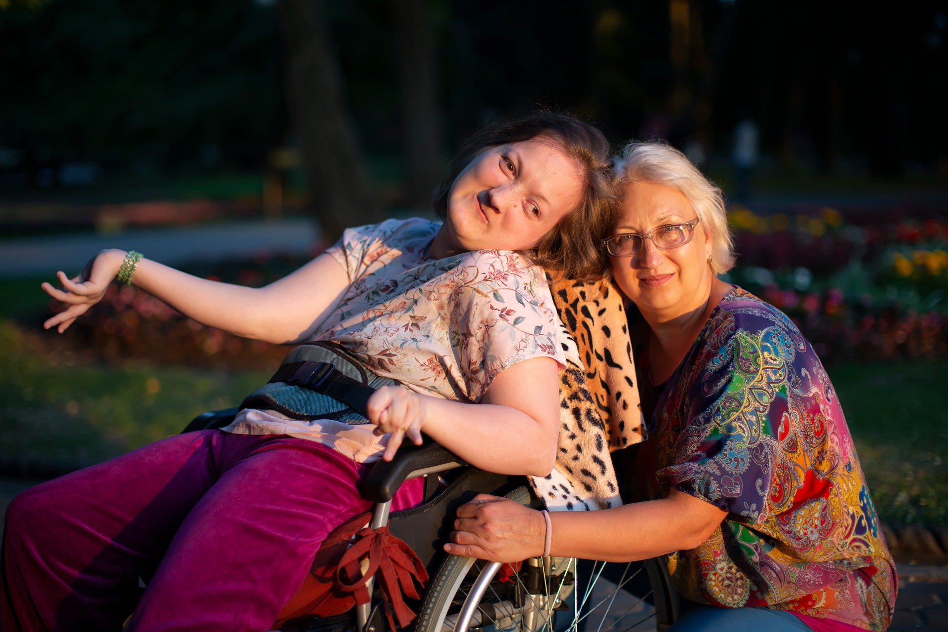 Well-groomed woman in a wheelchair with a guardian.Disabled woman with mom